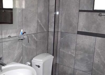 Modern bathroom with tiled walls, toilet, and sink