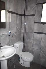 Modern bathroom with tiled walls, toilet, and sink