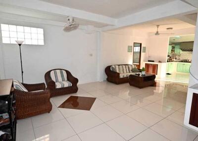 spacious living room with wicker furniture and tiled flooring