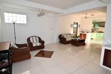 spacious living room with wicker furniture and tiled flooring