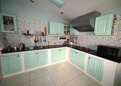 Modern kitchen with pastel green cabinets and tiled backsplash