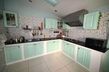 Modern kitchen with pastel green cabinets and tiled backsplash