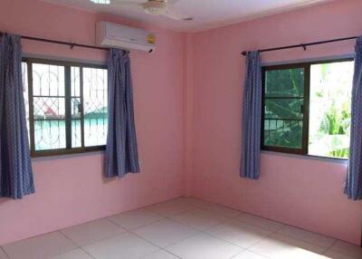 Bedroom with pink walls and two windows