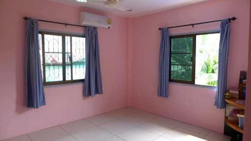 Bedroom with pink walls and two windows