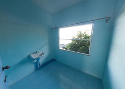 Bright bathroom with single sink and large window.