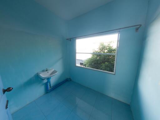 Bright bathroom with single sink and large window.