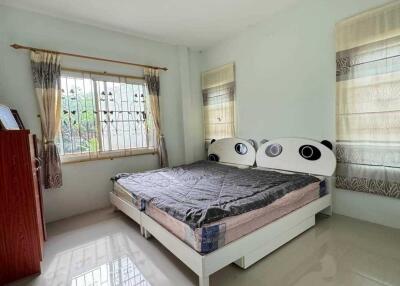 Well-lit bedroom with a window, bed, and dresser