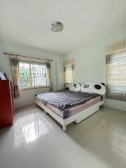 Well-lit bedroom with a window, bed, and dresser