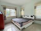 Well-lit bedroom with a window, bed, and dresser