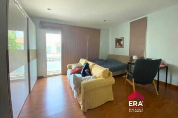 Spacious bedroom with a large window and seating area