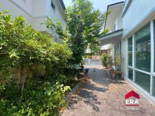 well-maintained garden with green plants and trees along the pathway