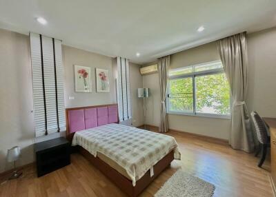 Modern bedroom with wooden flooring and natural light