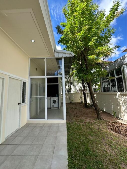 Outdoor area with a tiled patio, laundry room, and greenery