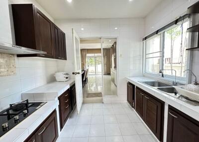 Modern kitchen with dark wood cabinetry and white countertops