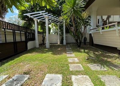 Well-maintained garden with paved pathway and pergola