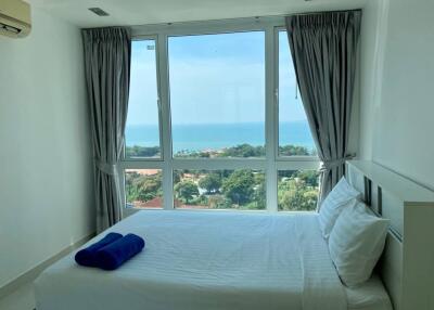 Modern bedroom with a large window offering a scenic ocean view