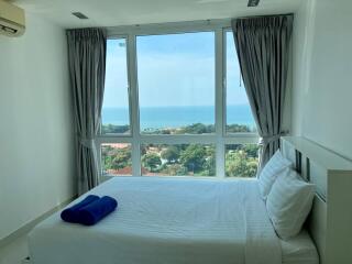 Modern bedroom with a large window offering a scenic ocean view