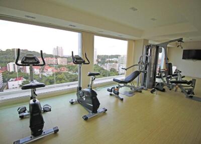 Indoor fitness center with exercise equipment and large windows