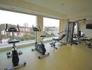 Indoor fitness center with exercise equipment and large windows