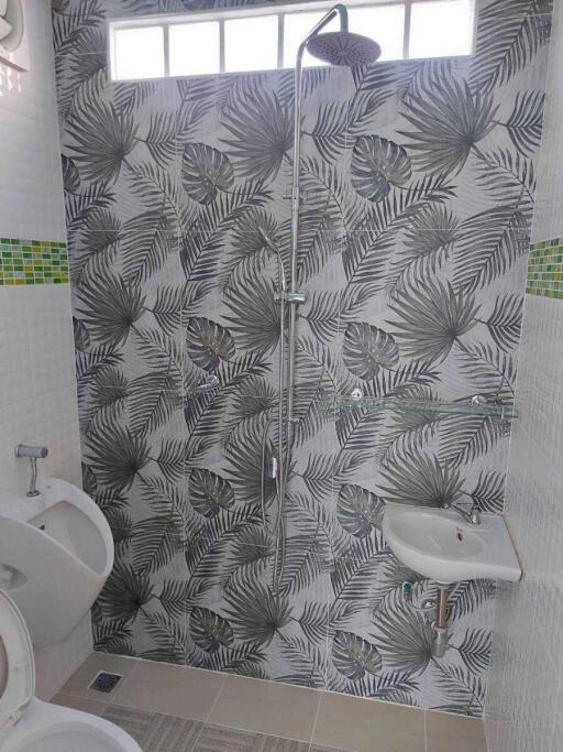 Bathroom with tropical leaf wallpaper and shower