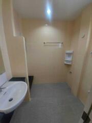 A small bathroom with a sink, towel rack, and a soap dispenser