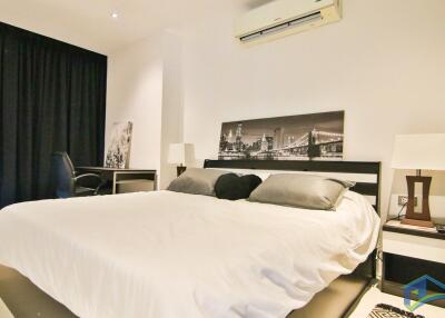 Modern bedroom with artwork, desk, and air conditioner