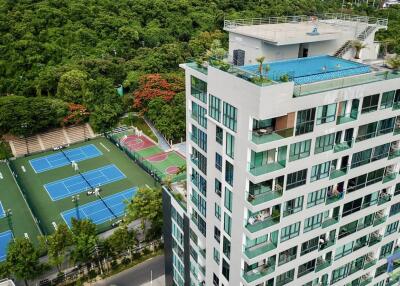 apartment building with rooftop pool and tennis courts