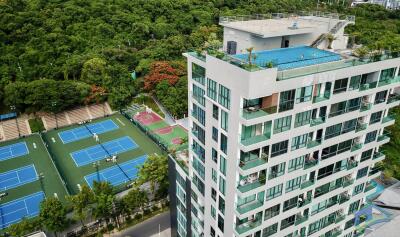 apartment building with rooftop pool and tennis courts