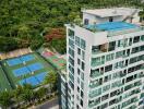 apartment building with rooftop pool and tennis courts