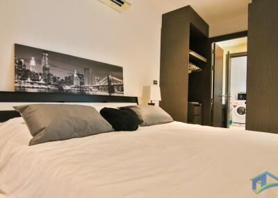 Modern bedroom with cityscape artwork above bed