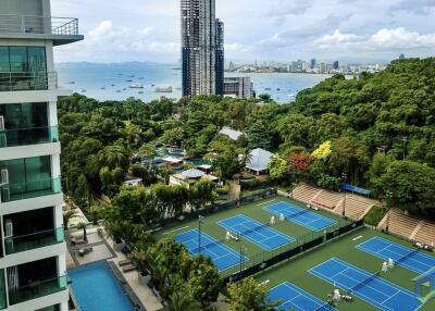 Scenic view of outdoor tennis courts, residential buildings, and city skyline