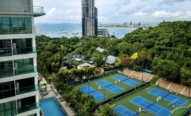 Scenic view of outdoor tennis courts, residential buildings, and city skyline