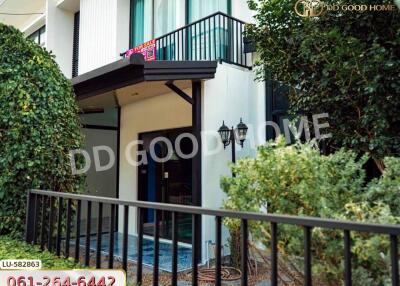 Modern two-story building with balcony and garden