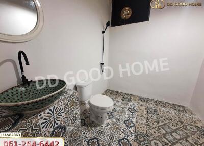 Bathroom with patterned tile flooring, sink, toilet, and shower area