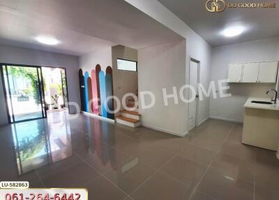 Spacious living area with access to the garden, featuring a multi-colored accent wall and tiled flooring