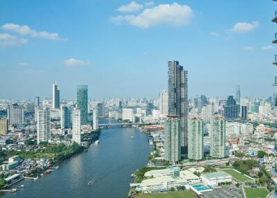 Cityscape view of modern buildings and river under a bright blue sky