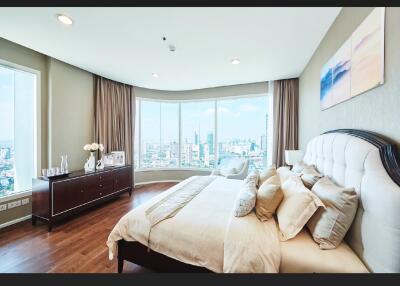 Spacious bedroom with large windows and city view