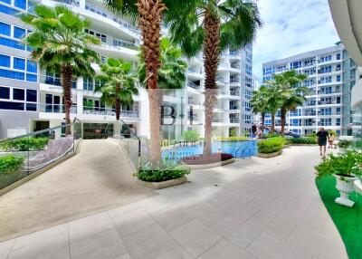 A modern residential complex with palm trees and outdoor amenities