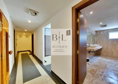 Building hallway leading to a spacious bathroom