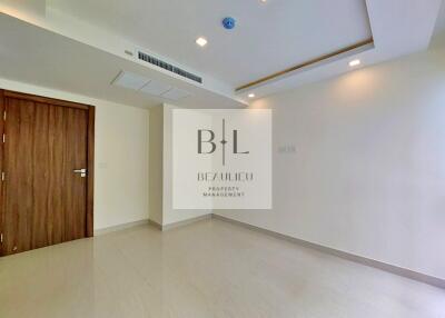 Empty bedroom with wooden door and ceiling lights