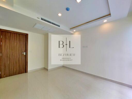 Empty bedroom with wooden door and ceiling lights