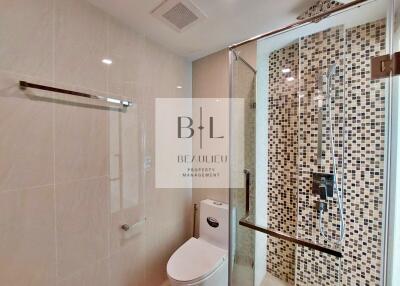 Modern bathroom with glass-enclosed shower and mosaic tile wall