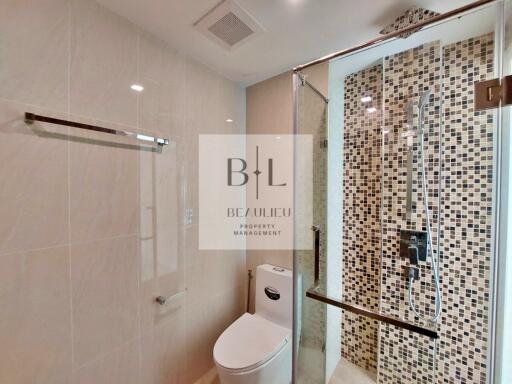 Modern bathroom with glass-enclosed shower and mosaic tile wall