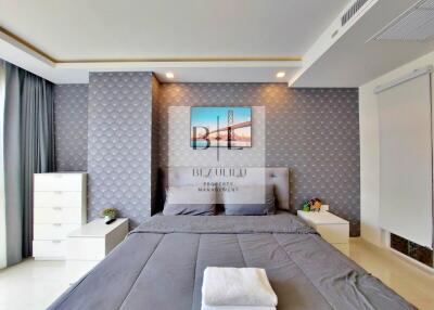 Modern bedroom with bed, bedside tables, and artwork