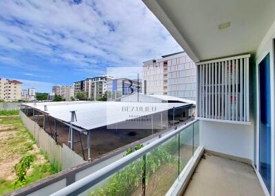 Balcony with view of covered parking and buildings