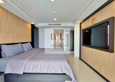 spacious modern bedroom with mounted TV