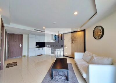 Modern living room with white sofa, wall clock, and entertainment area