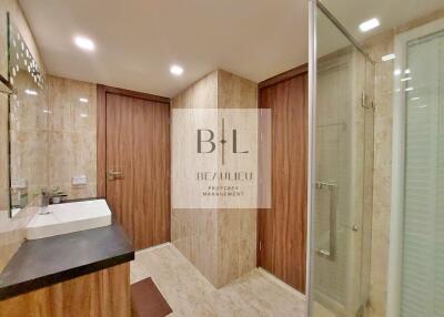 Modern bathroom with sink, wooden doors and glass shower