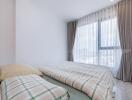 Bright bedroom with large window and plaid bedding