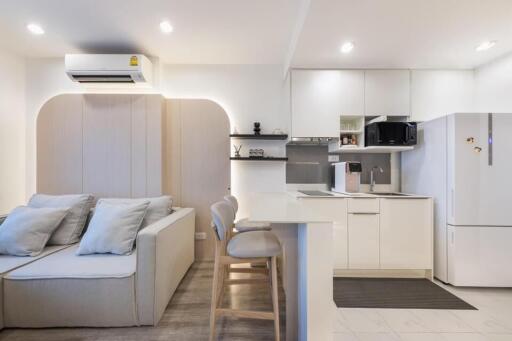 Modern kitchen and living area with sofa and bar stools